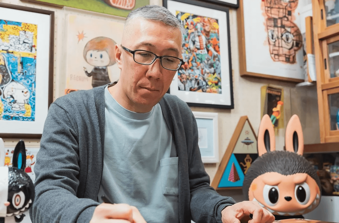 Kasing Lung sketching Labubu in his studio, surrounded by art supplies