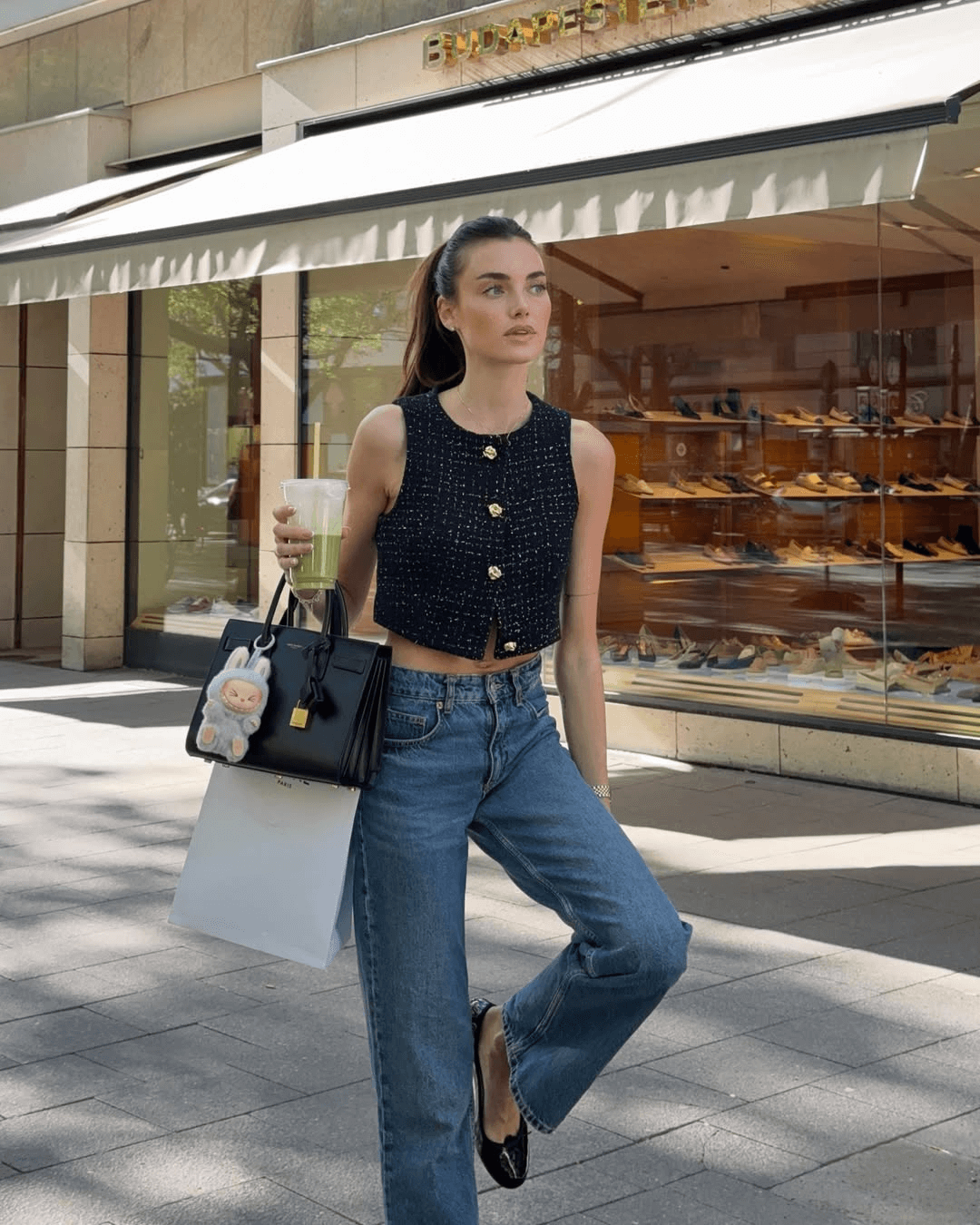 A celebrity carrying a designer bag adorned with a Labubu keychain