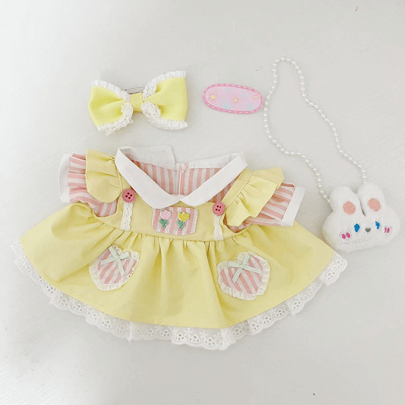 A Labubu doll with DIY clothes, surrounded by sewing tools and fabric scraps